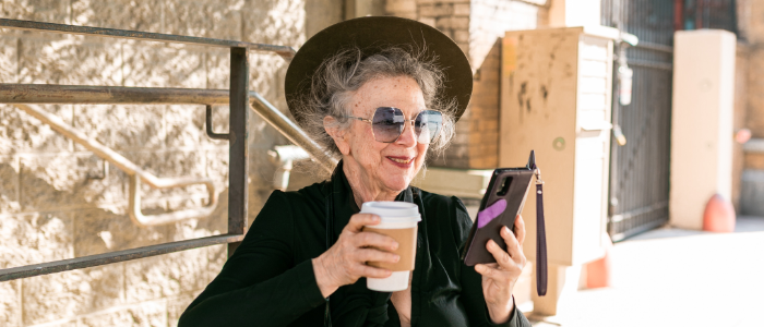 Woman holding a phone and a coffee